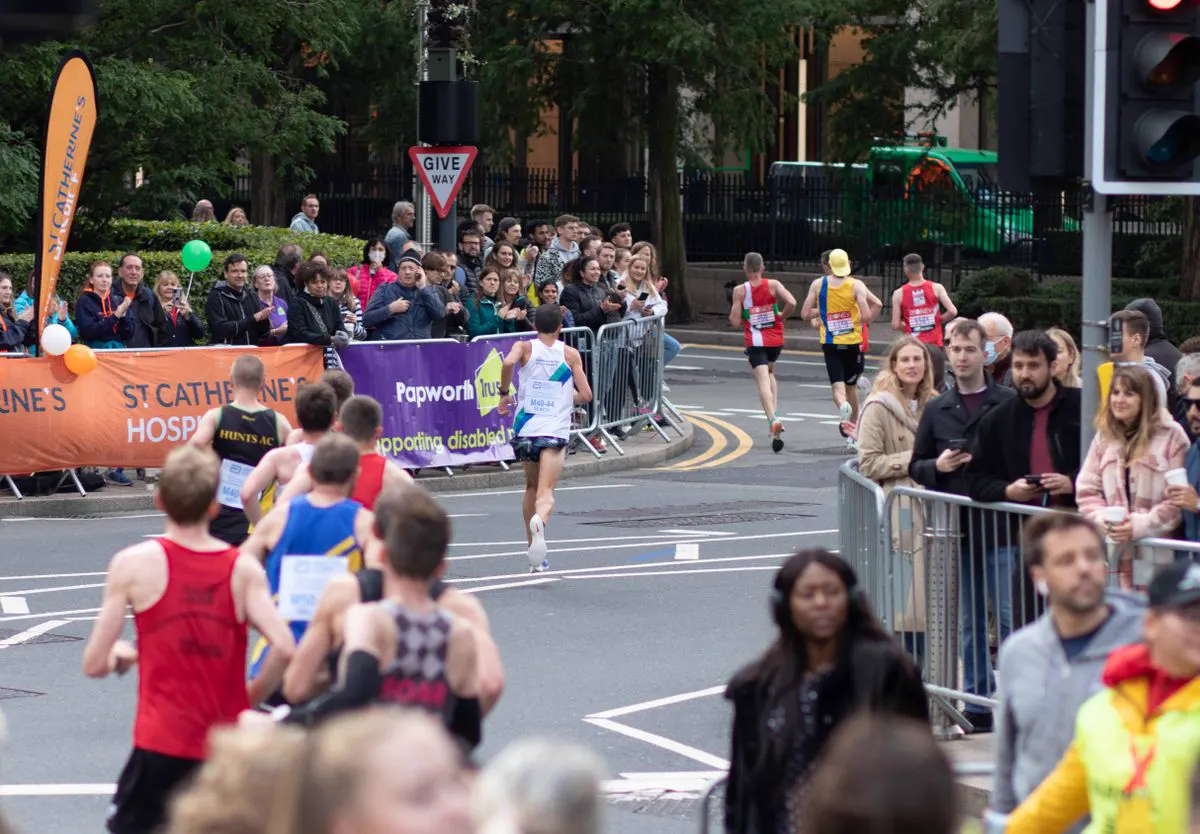 Runners passing a crowd at a charity fun run