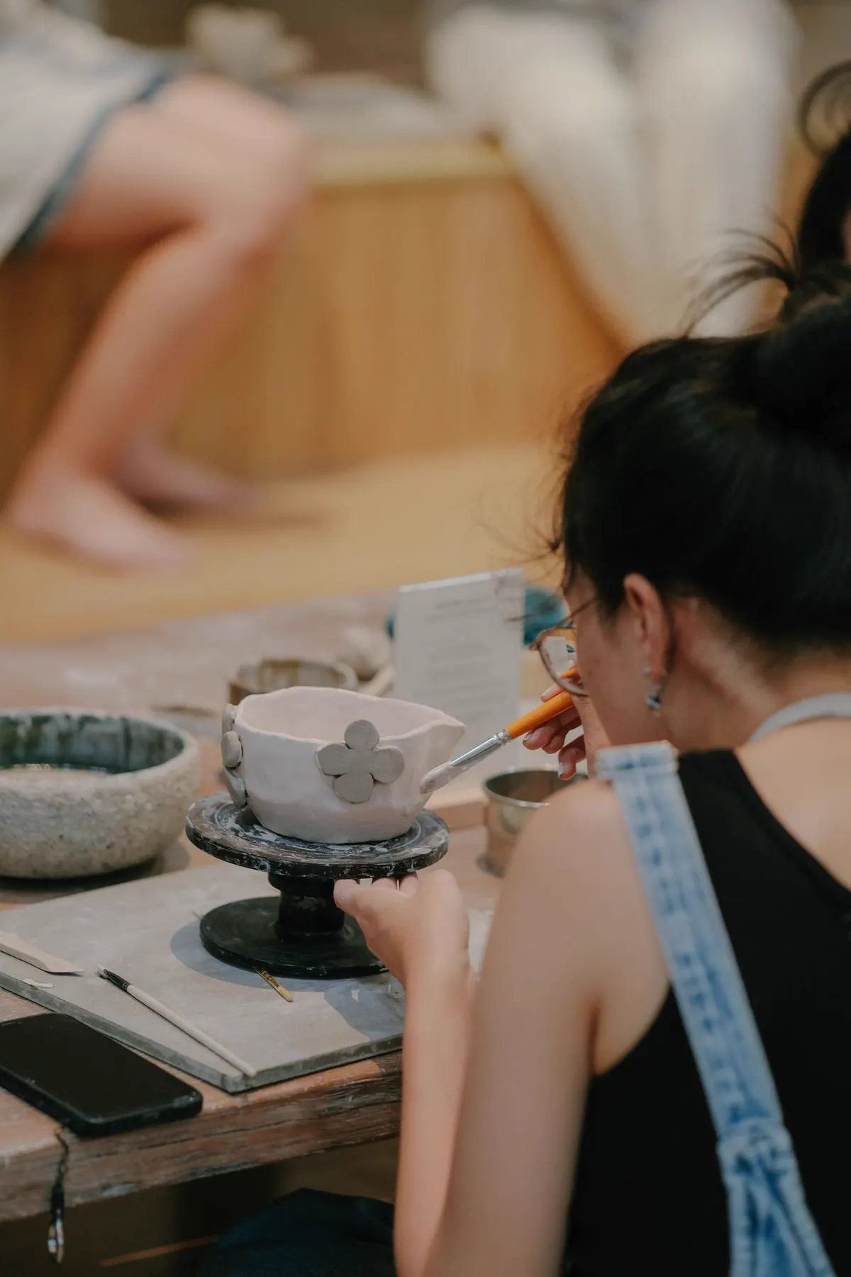 Hands shaping clay at a pottery workshop